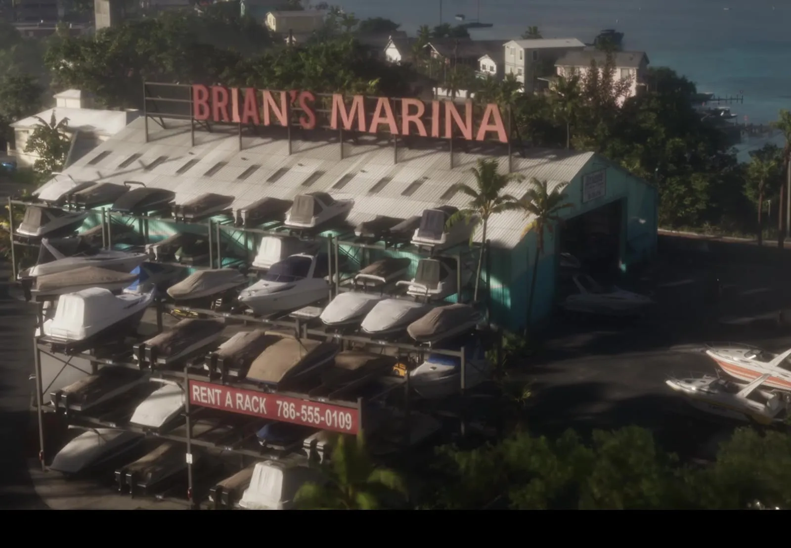 С высоты: вывеска BRIAN'S MARINA над стеллажами с лодками, за ней залив